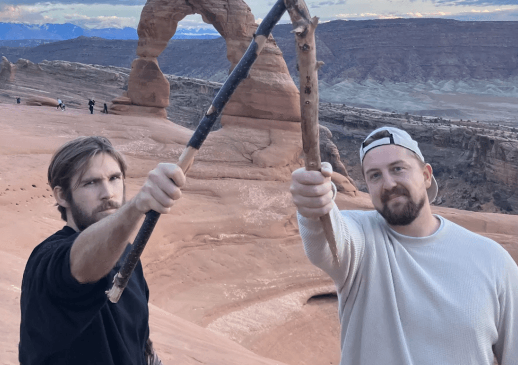 Founders Boone Hogg and Logan Jugler holding sticks outdoors